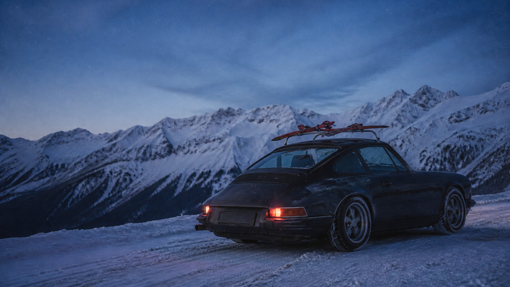 Auto z nartami na śnieżnej, alpejskiej drodze